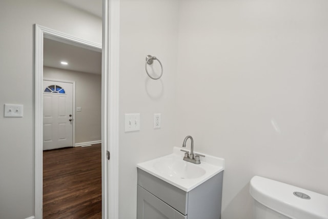 bathroom with hardwood / wood-style floors, vanity, and toilet