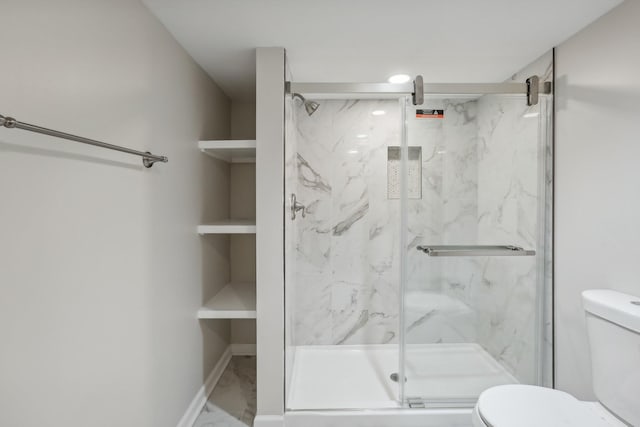 bathroom featuring toilet and a shower with door