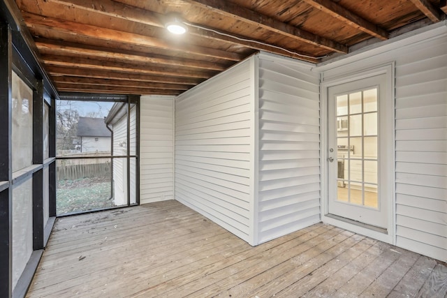 unfurnished sunroom featuring beamed ceiling and wood ceiling