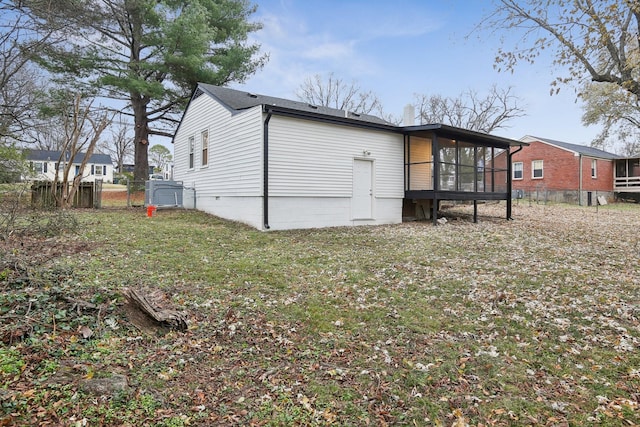 back of house with a lawn and a sunroom