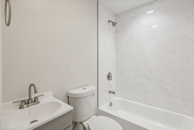 full bathroom featuring vanity, tiled shower / bath combo, and toilet