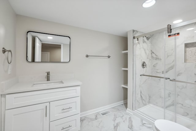 bathroom featuring vanity, a shower with shower door, and toilet