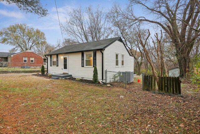 view of front of home with a front lawn and central air condition unit