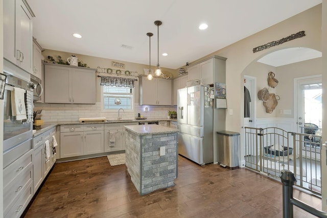 kitchen featuring hanging light fixtures, dark hardwood / wood-style flooring, a center island, and stainless steel appliances