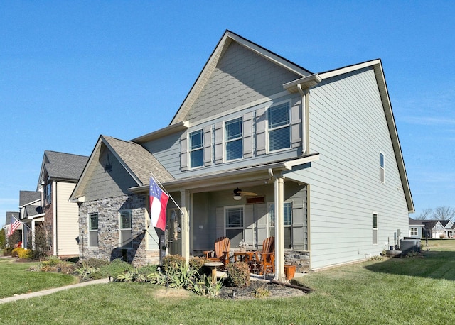 view of front of home with ceiling fan, covered porch, and a front yard