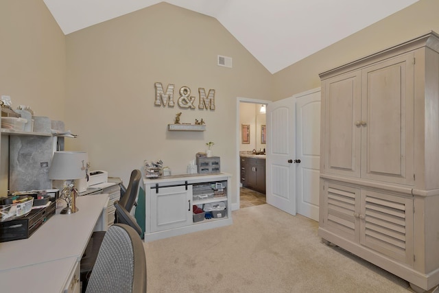 office area with light colored carpet and vaulted ceiling