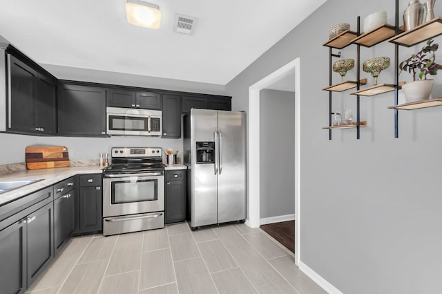 kitchen featuring light stone countertops and stainless steel appliances