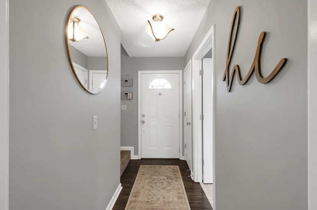 doorway to outside featuring a textured ceiling and dark hardwood / wood-style flooring