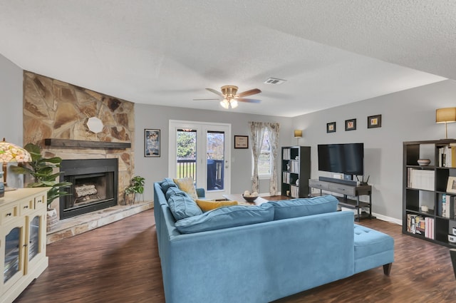 living room with a textured ceiling, a fireplace, and dark hardwood / wood-style floors