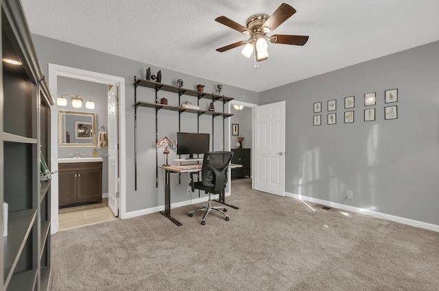 carpeted office featuring a textured ceiling and ceiling fan