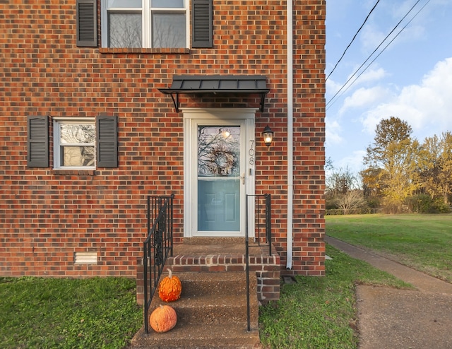 view of exterior entry featuring a yard