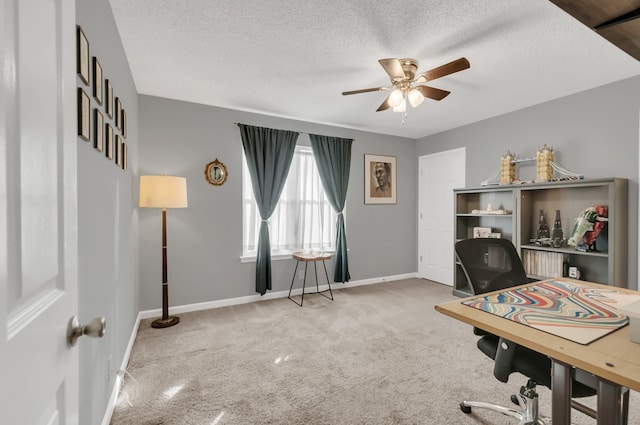 carpeted office space featuring ceiling fan and a textured ceiling