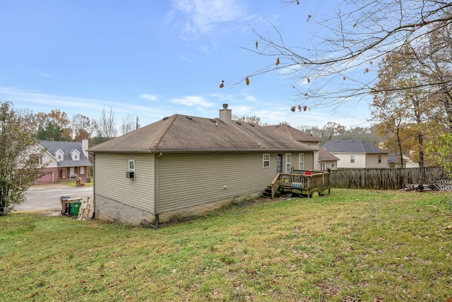 rear view of house featuring a lawn and a deck