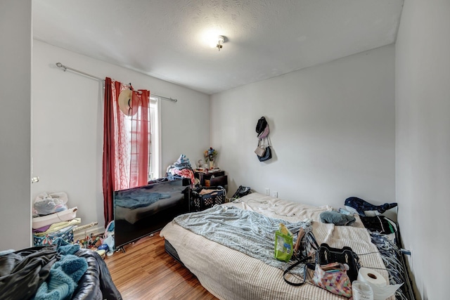 bedroom with wood-type flooring and a textured ceiling