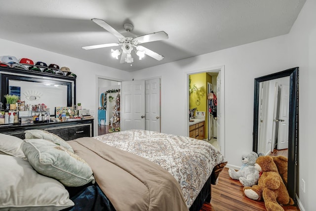 bedroom featuring hardwood / wood-style flooring, ceiling fan, connected bathroom, and indoor bar