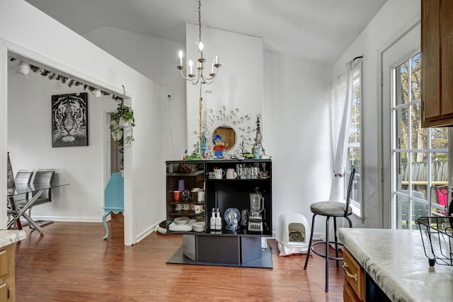 living room with dark hardwood / wood-style flooring, vaulted ceiling, and a notable chandelier