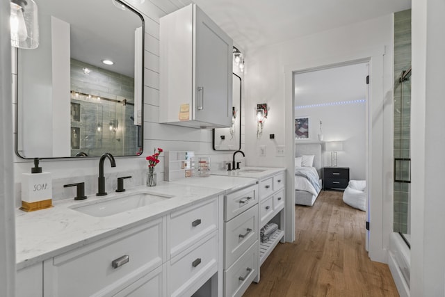 bathroom with backsplash, hardwood / wood-style floors, vanity, and walk in shower