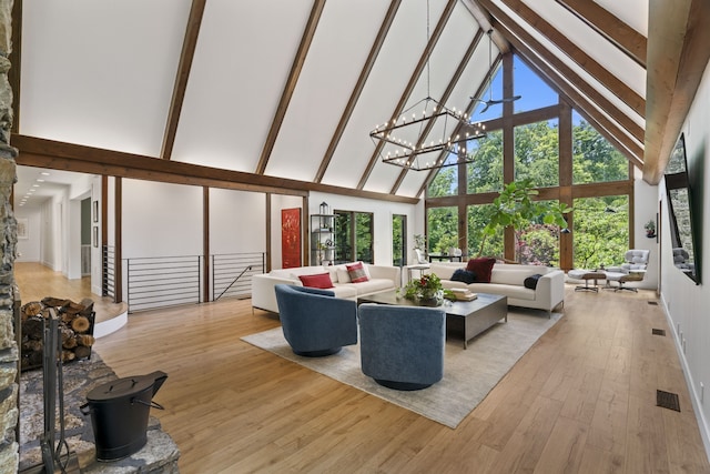 living room with beamed ceiling, light hardwood / wood-style flooring, high vaulted ceiling, and a chandelier