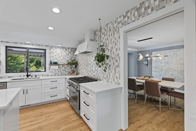 kitchen featuring sink, white cabinets, stainless steel appliances, and light wood-type flooring