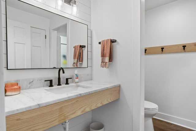 bathroom with hardwood / wood-style flooring, toilet, and sink