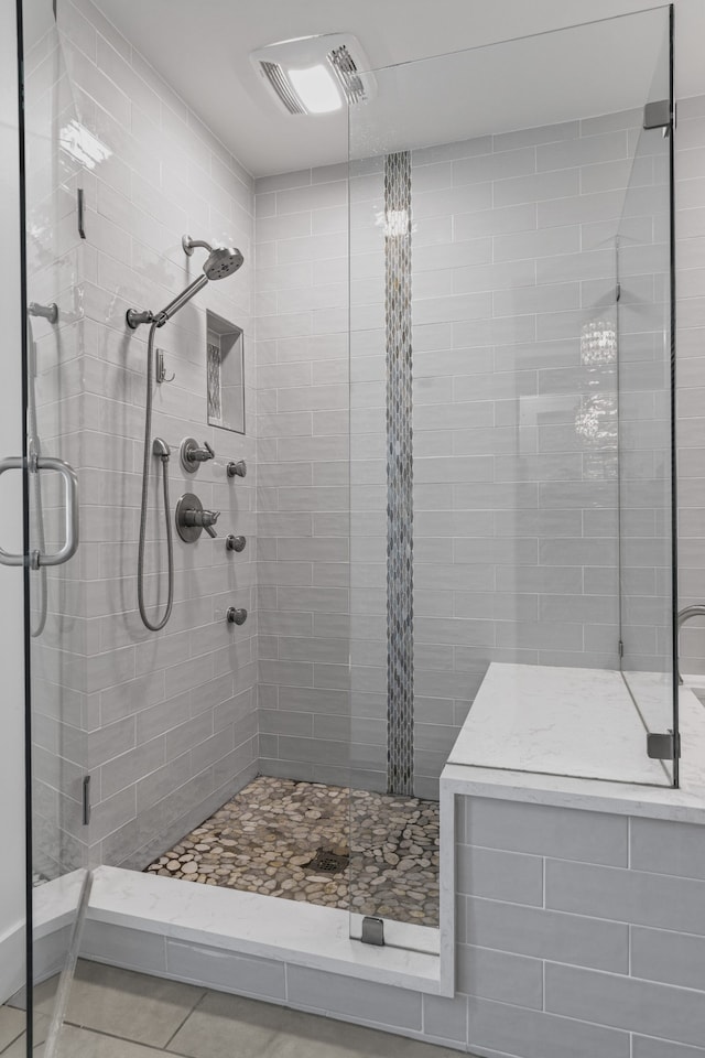 bathroom featuring tile patterned flooring and an enclosed shower