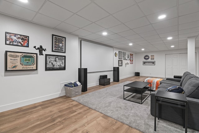 living room featuring wood-type flooring and a paneled ceiling