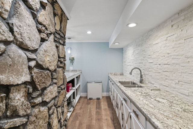 kitchen featuring light stone countertops, sink, decorative light fixtures, dark hardwood / wood-style floors, and white cabinetry