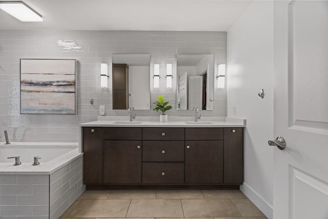 bathroom featuring tile patterned flooring, a relaxing tiled tub, and vanity