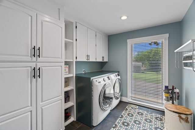 washroom featuring cabinets, separate washer and dryer, and dark tile patterned flooring