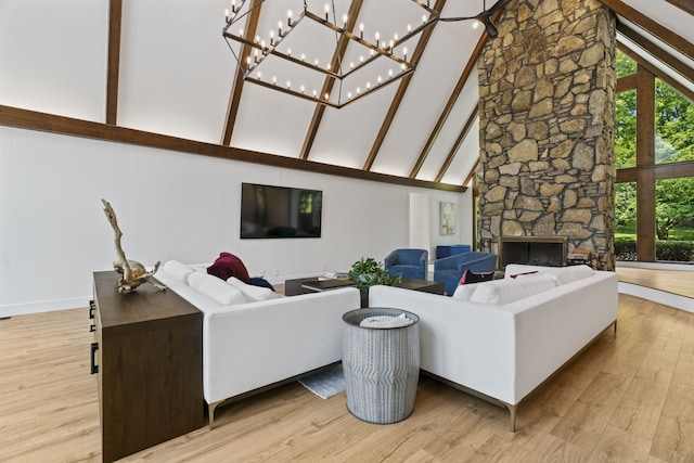 living room with beamed ceiling, high vaulted ceiling, light hardwood / wood-style flooring, and a stone fireplace