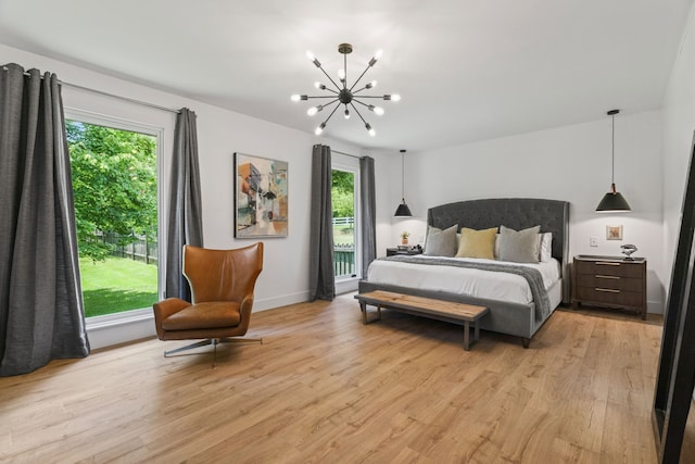 bedroom with a chandelier, light wood-type flooring, and multiple windows