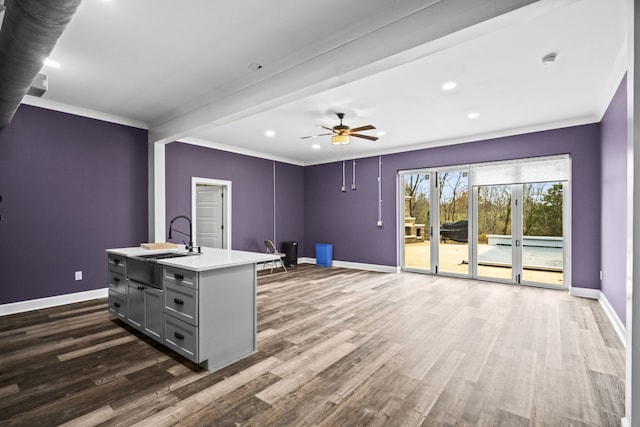 unfurnished office with ceiling fan, dark hardwood / wood-style flooring, ornamental molding, and sink