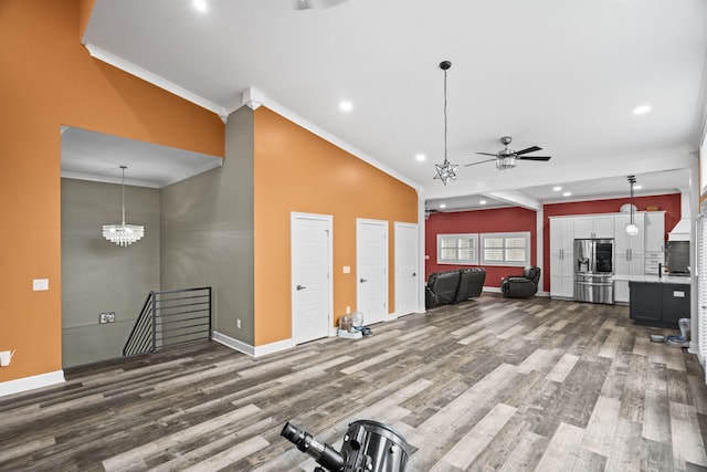 interior space featuring wood-type flooring, ceiling fan, vaulted ceiling, and crown molding