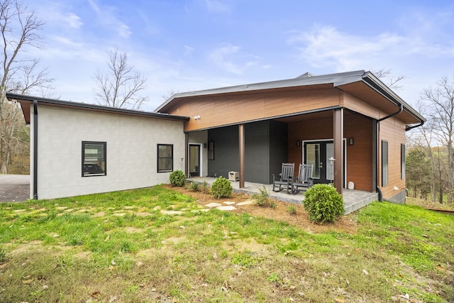 rear view of property with a patio and a yard