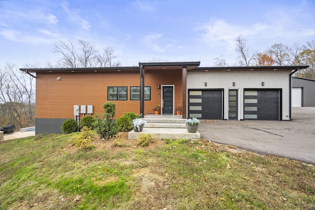 contemporary house with a front yard and a garage