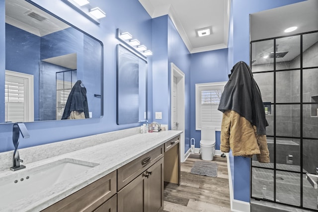 bathroom featuring toilet, hardwood / wood-style floors, a shower with door, crown molding, and vanity