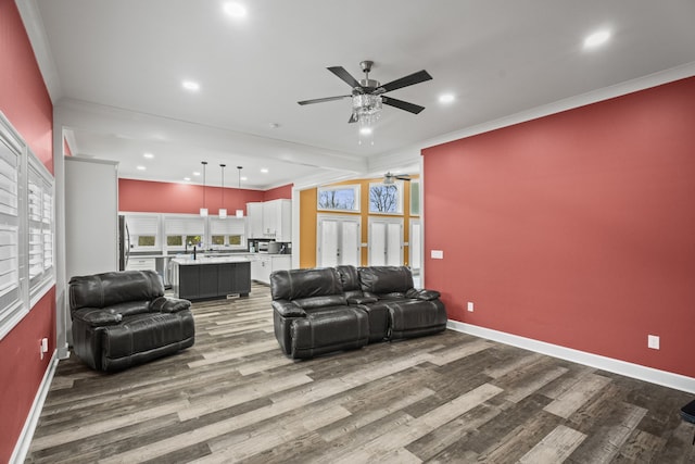 living room with ornamental molding, ceiling fan, hardwood / wood-style floors, and plenty of natural light