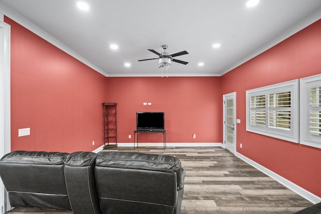 living room featuring wood-type flooring, ornamental molding, and ceiling fan