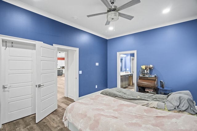 bedroom with ceiling fan, connected bathroom, crown molding, and wood-type flooring