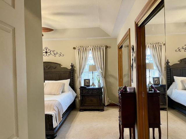 carpeted bedroom with a closet and vaulted ceiling