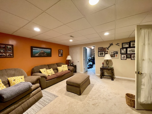 living room with carpet flooring and a paneled ceiling