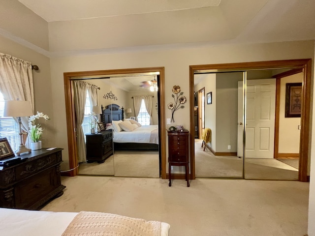 bedroom featuring multiple closets and light colored carpet