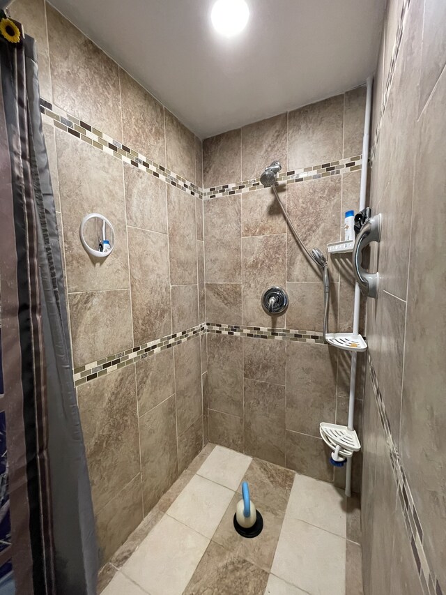 bathroom featuring curtained shower and tile patterned flooring