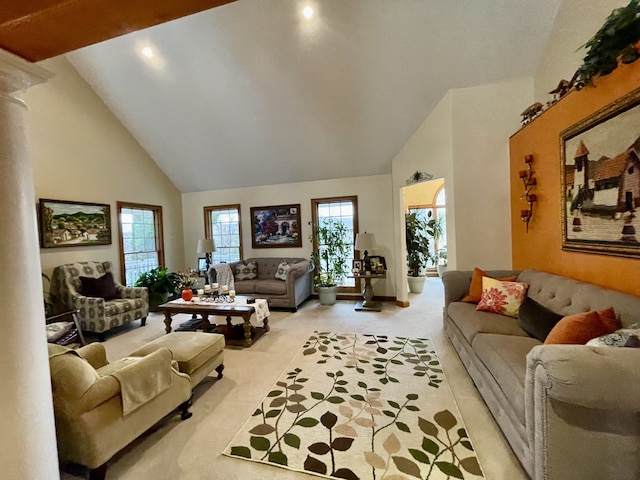 carpeted living room with high vaulted ceiling and ornate columns