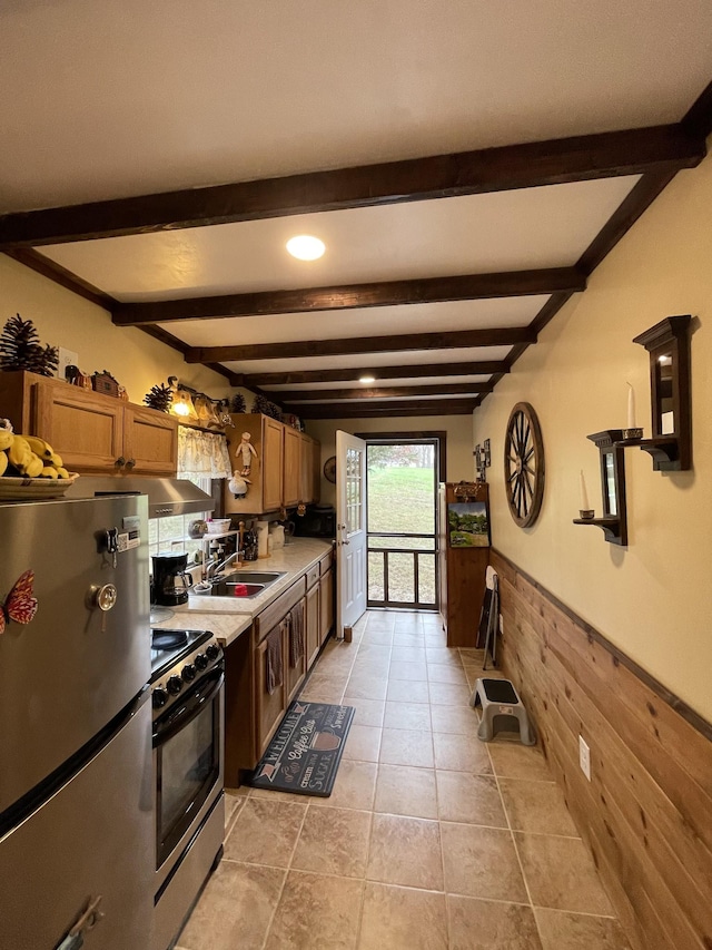 314 Birdsong Dr, Cadiz, KY 42211 - kitchen featuring freestanding refrigerator, stainless steel gas range oven, wainscoting, beam ceiling, and light countertops
