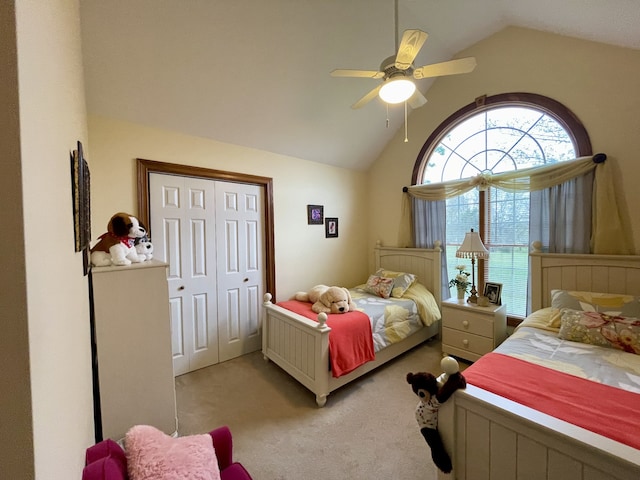 carpeted bedroom with ceiling fan, a closet, and lofted ceiling