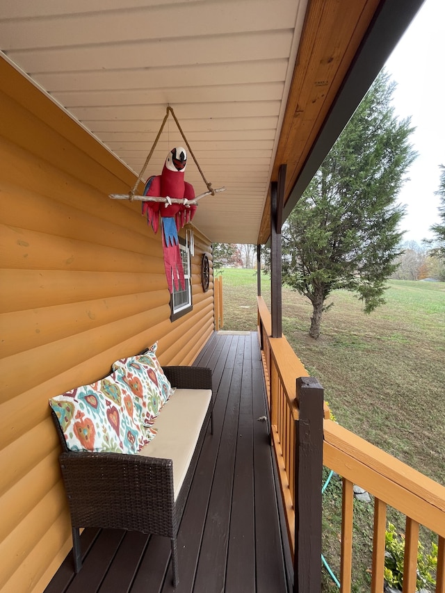 wooden terrace featuring a lawn