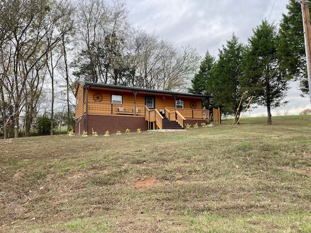 log cabin with a wooden deck and a front lawn