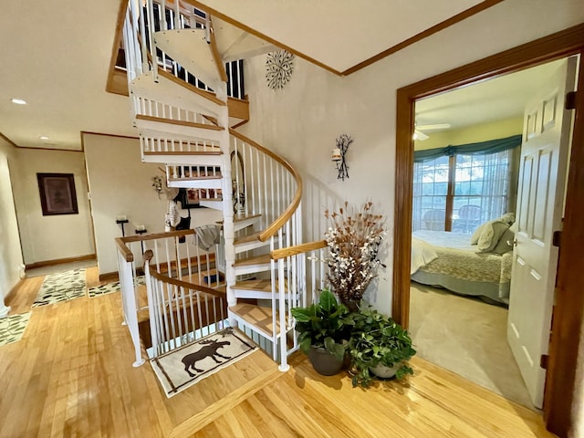 staircase with hardwood / wood-style flooring and ornamental molding