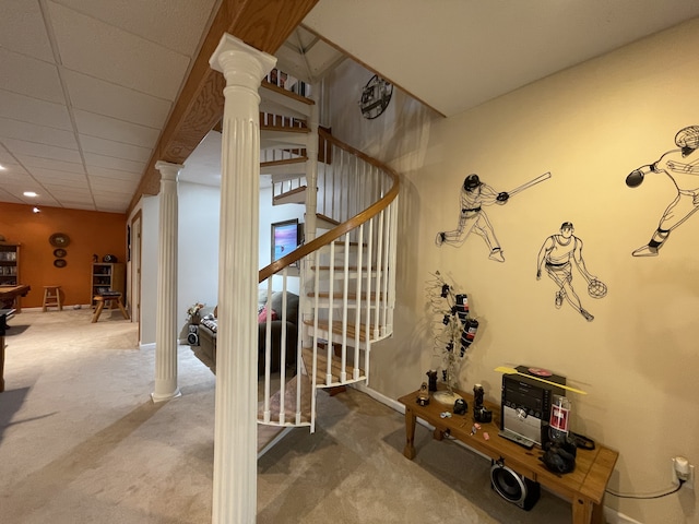 stairs featuring carpet flooring, decorative columns, and a drop ceiling